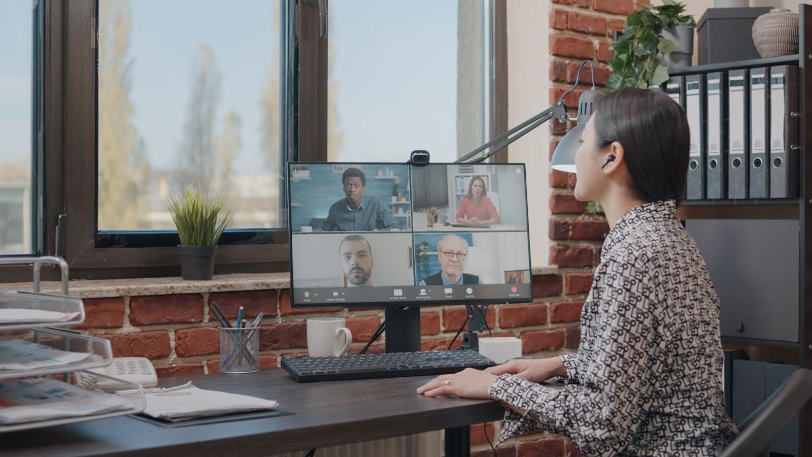 A woman having a video conference call with colleagues in a office